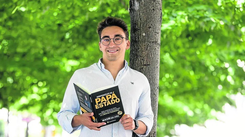 carlos-galan-libro-independizate-papa-estado.webp Carlos Galán posa al aire libre sosteniendo su libro Independízate de Papá Estado